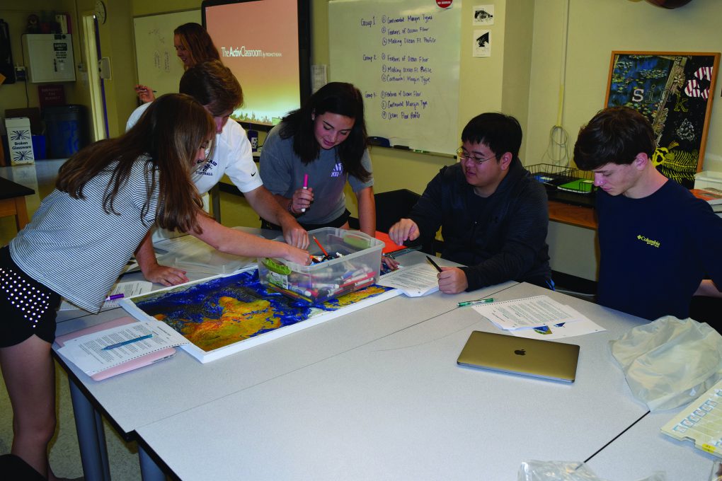 Seniors Allison Favaloro, Jack Tower, Belle Martire, David Liang, and Will Langford learn about the features of the sea floor on a topographical map in Marine Science. Photo by: Katherine Montgomery.