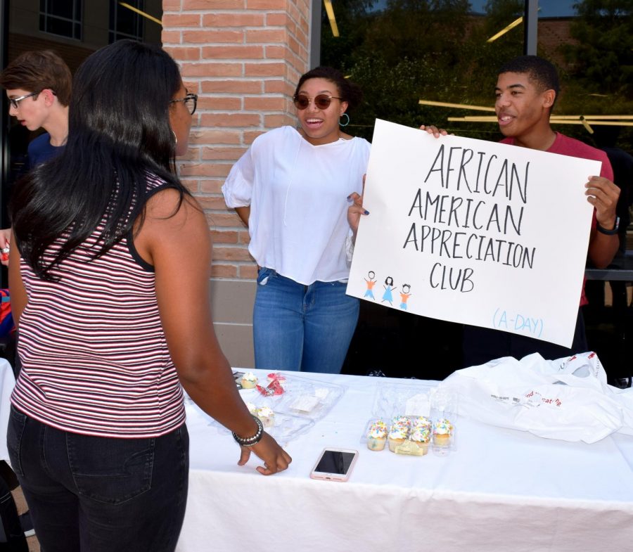 Senior Haylie Sims speaks with her peers, Jasmine Wright and Nicholas Dillon, as they tried to attract new members Monday during Club Fair. The annual event is held in the quad, which is transformed into a bazaar with booths, food and activities. 
