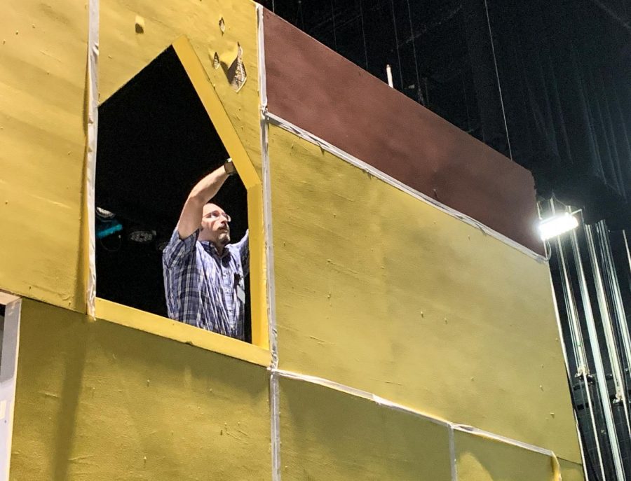Mr. BJ Garmon, technical theatre co-director, puts final touches on a piece of the set for the schools performance of Disneys Beauty and the Beast.