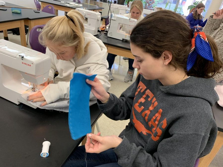 Sophomore Eliza Mitchell learns how to use a sewing machine, while her friend Brooke Jacobe, who is also a sophomore, practices stitching by hand. The girls are students in "Sewing for Beginners," an Interim Term class.