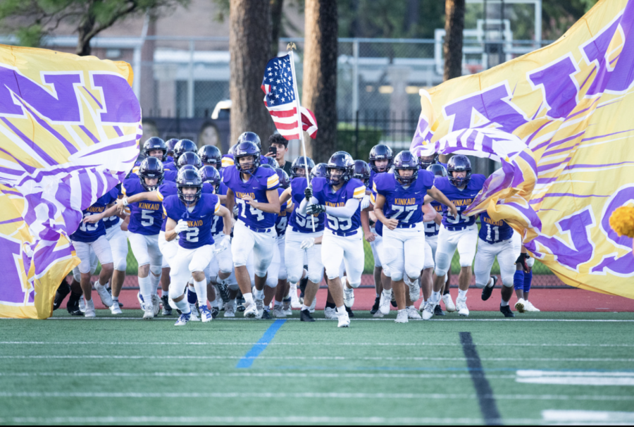 The+Kinkaid+football+team+charges+forward%2C+with+Klosek+carrying+the+American+flag.+