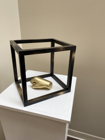 This picture is of a golden hand in a black cube.