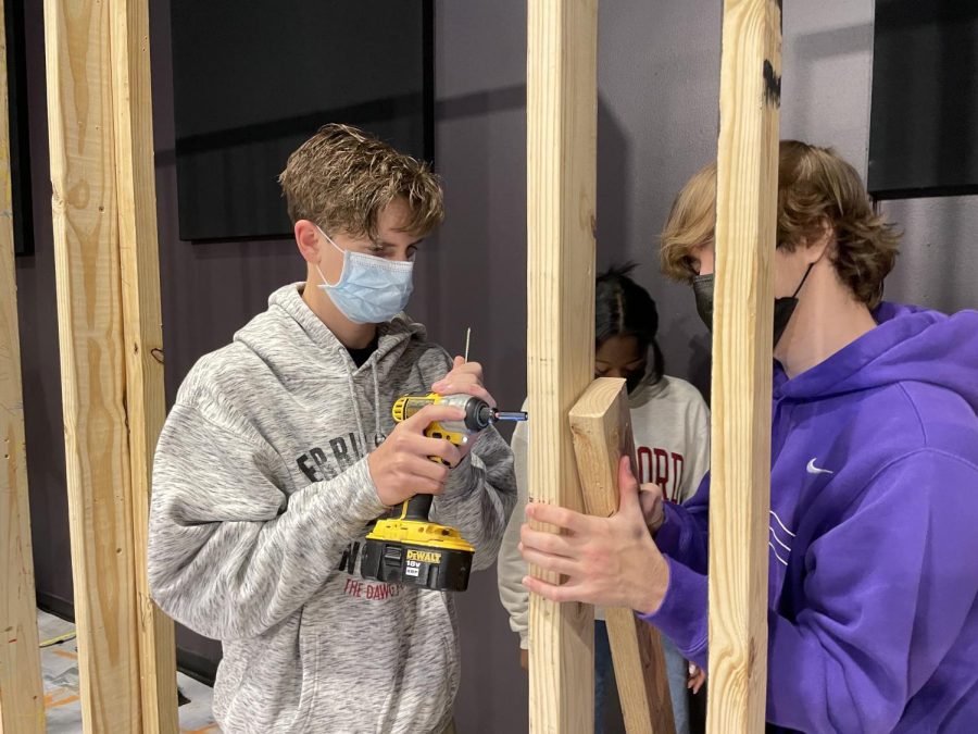 Juniors Baley Metclaf, Kima Ukpong and Gabriel Meyers  assemble a wooden frame that will become the setup for a wall in their Fixer Upper class.