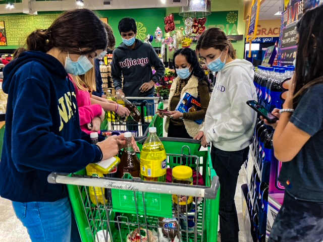 Students count their scavenger hunt items in Fiesta Mart to determine the winner.