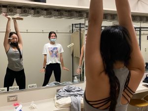 Juniors Madison Doan and Ashlyn Gilhooley stretch in a dressing room before taking their hip hop dance class.