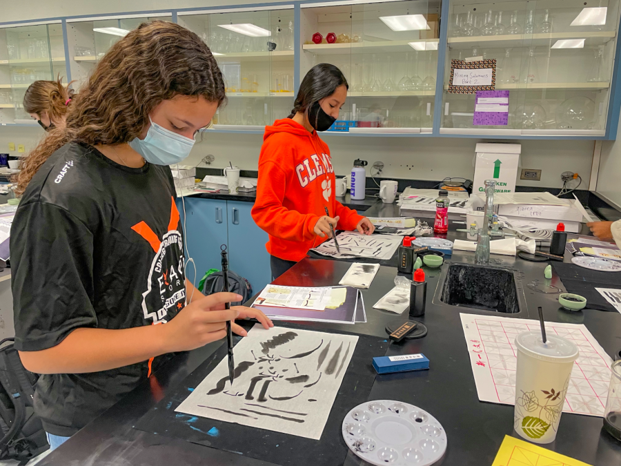 Lia Bonet, junior, and Gianna Cruz, sophomore, painting in their Chinese watercolor class.