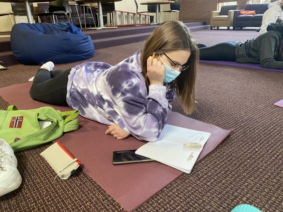 Maria Bruno, junior, writes in her journal during her yoga class. 