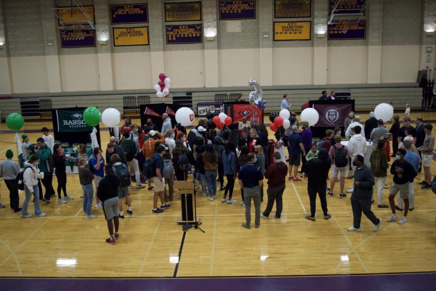 Crowds swarm around the four athletic commits as they celebrate.