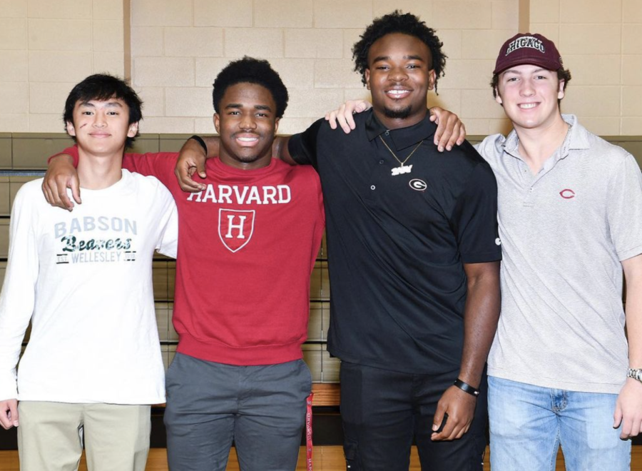 Doan, Henry, Bell and Kelsey pose for a photo after signing.