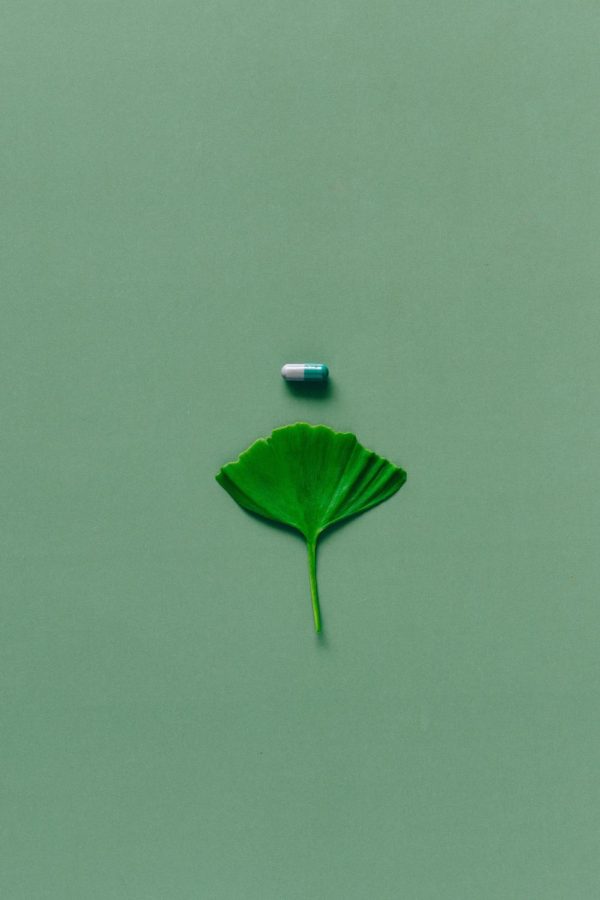 A green pill and leaf, illustrating the threat of drugs. 