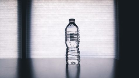 A plastic water bottle by the windowsill. 