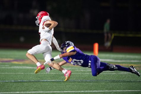 A Falcon football player takes down a St. Johns player in a 2021 matchup.