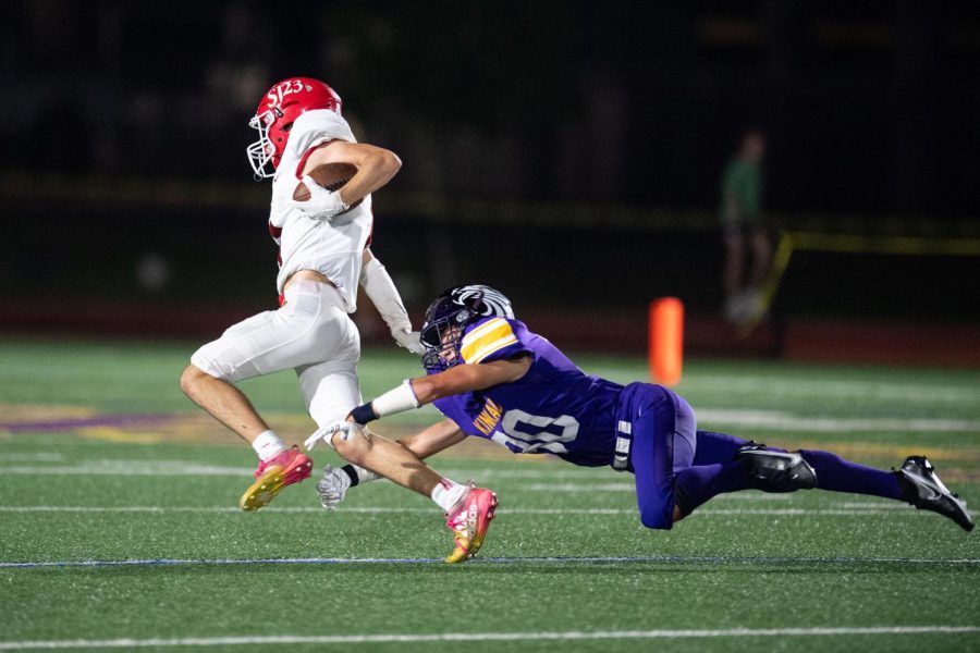 A Falcon football player takes down a St. John's player in a 2021 matchup.