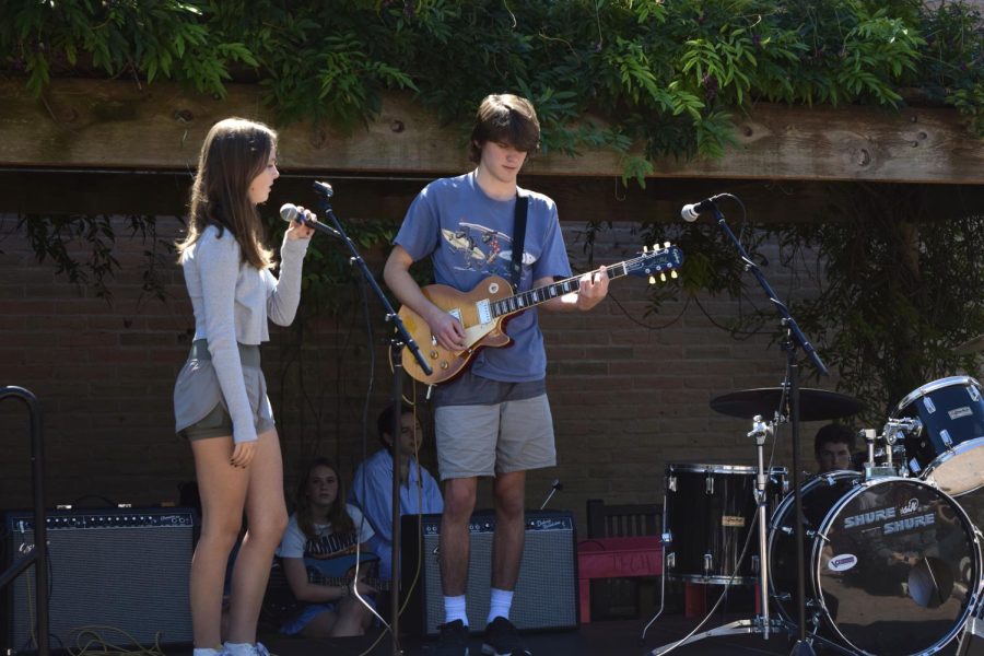Junior Claire Hartung watches junior Patrick Reilly play a guitar riff during Electric Lunch’s performance.