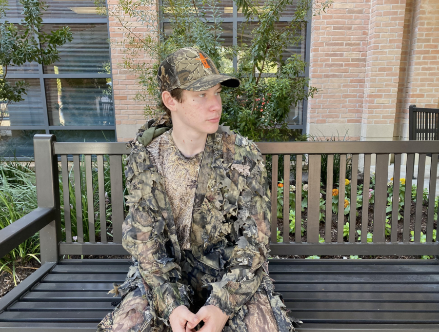 Matthew Berman ‘25 looks off into the distance fully decked out in camo spirit wear.