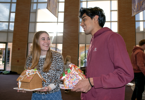 Seniors Jaisal Kalapatapu and Taylor McMullen smile with gingerbread houses in hand. 