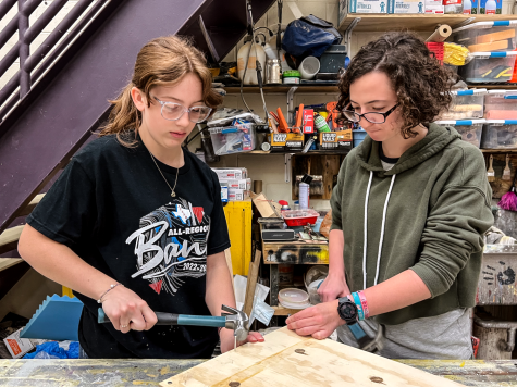 Sophomore Katherine Rush and junior Ella Gillentine learn the correct technique for hammering, making sure to keep the nail straight. Their class titled Fixer Upper centered on working together to learn more skills. “Working together makes a process more effective, time efficient, and also fun, Gillentine said.