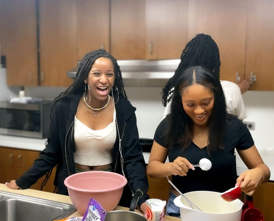 Junior Rayya James and sophomore Shelby Haskett work together on a dish. James mixed cheese with sour cream while Haskett helped.