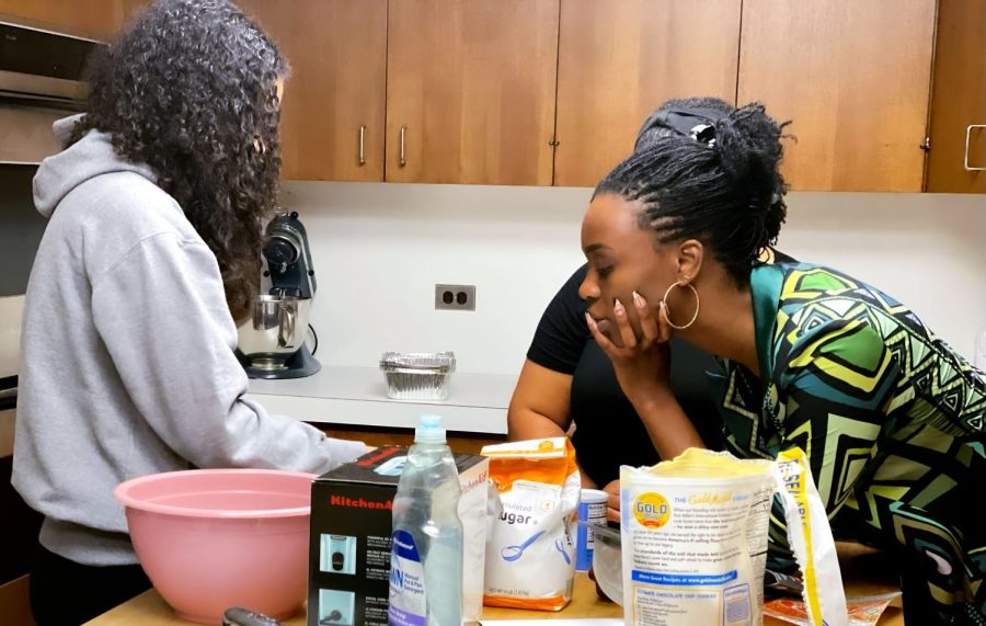 One of the teachers of "Beyond The Plate," Ms. Mujidat Shotonwa, director of diversity, equity and inclusion, directs sophomore Ellie Bynam as she prepares ingredients. Bynam was making a pound cake. 
