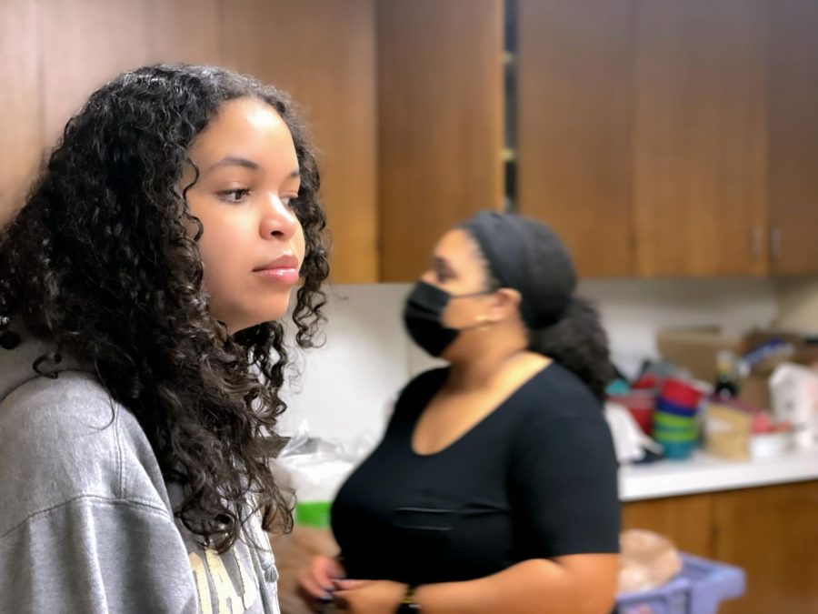 Sophomore Ellie Bynam watches over a classmate who is preparing a pan for the pound cake with her teacher Mrs. Erica Baker, student life director, in the background. Bynam used the pan to place a pound cake batter into an oven.
