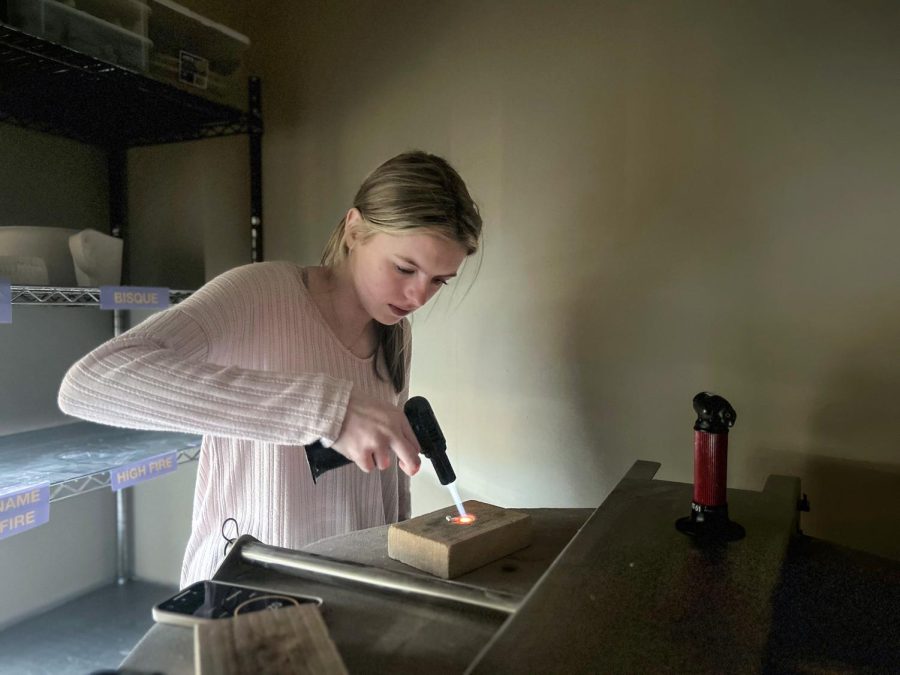 Junior Eloise Klaasmeyer uses a blow torch to fire her silver clay. When she fires the silver clay all the molecules come to the middle and the clay shrinks in size and turns into a hard metal.