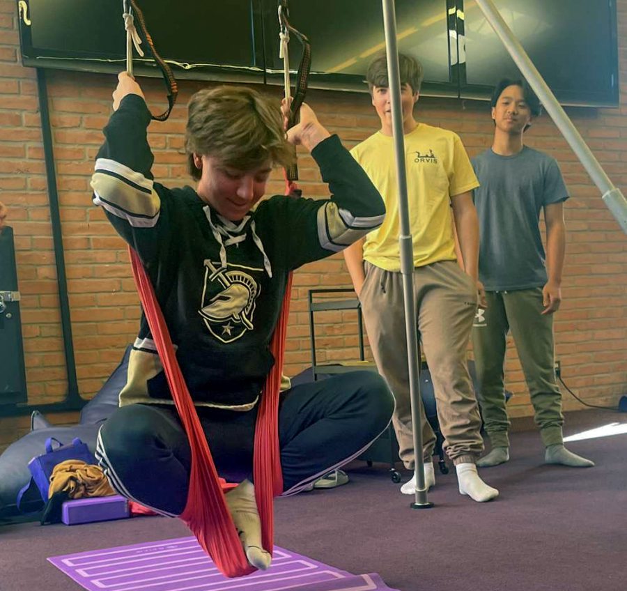 Max Roeder, a sophomore, tries aerial yoga while his peers observe him. The students were practicing yoga in the Interim Term class, "Yoga and Wellness."