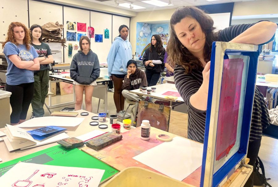 Ms. Megan McEntire, Upper School art teacher, demonstrates the steps for her students' silkscreen project in their Interim Term class.
