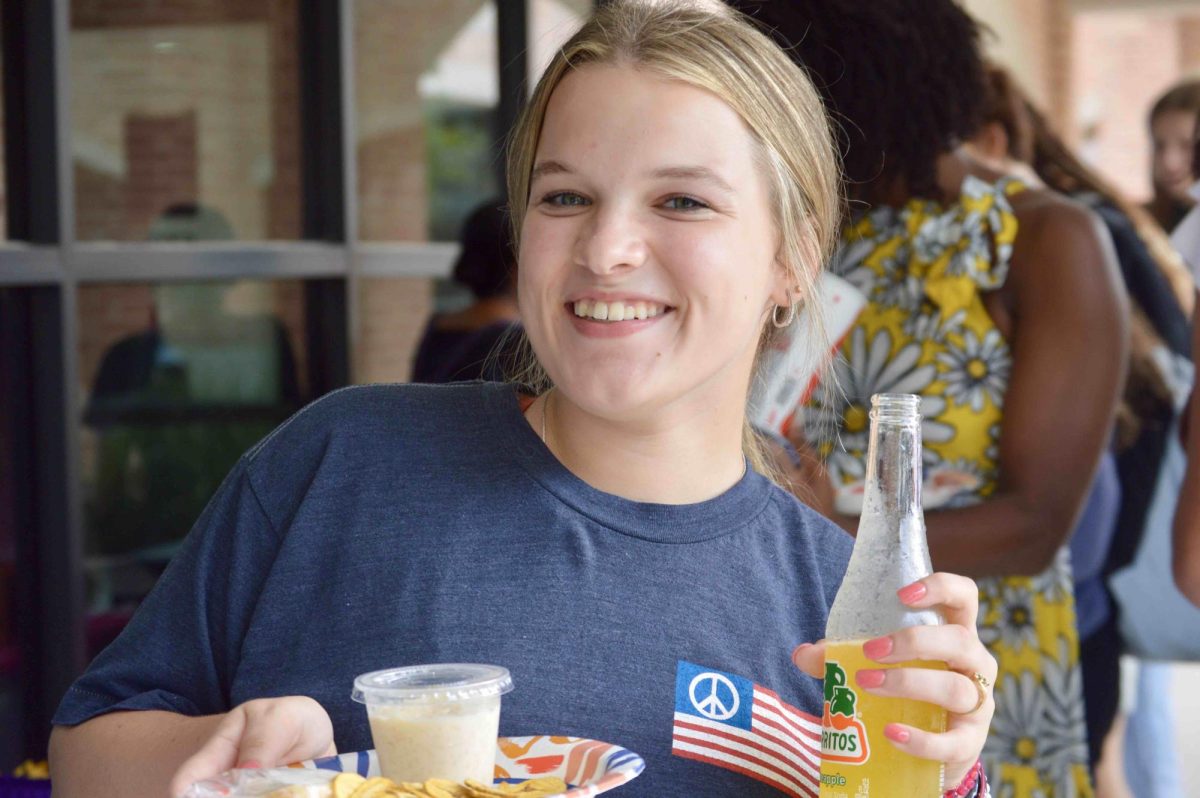 Junior Marisa Boué enjoys her Jarritos soda and snacks at the Hispanic Heritage Month fiesta for students.