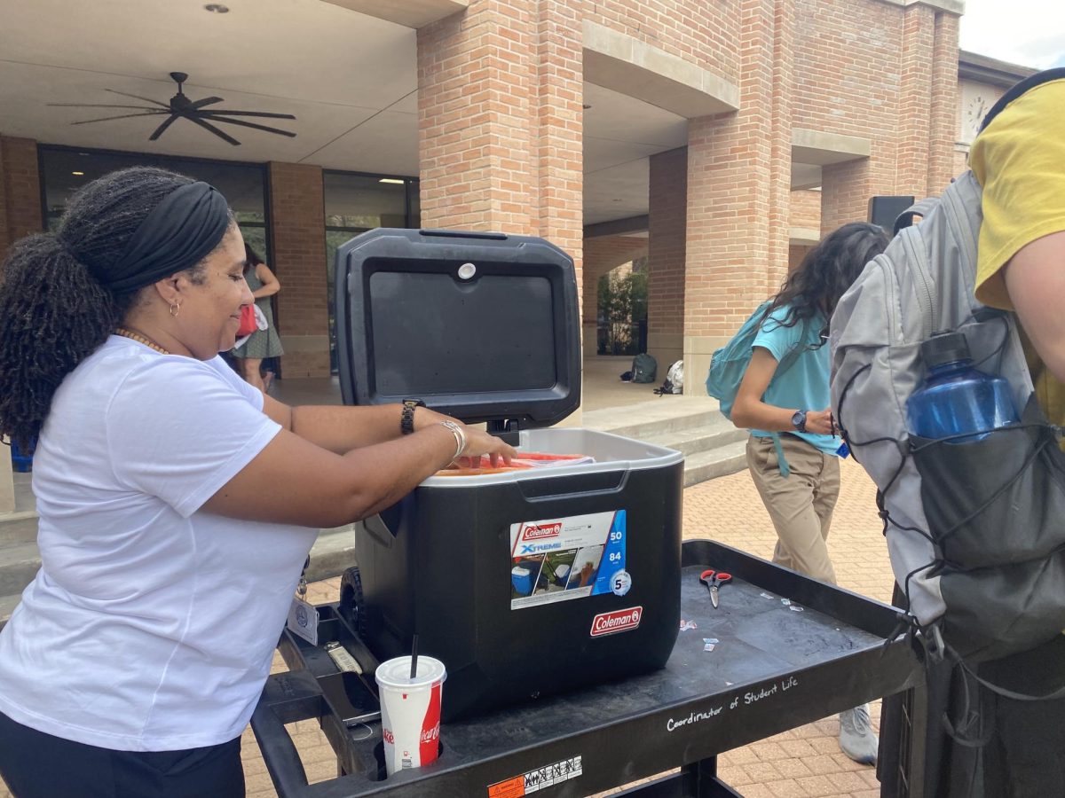 Erica Baker, Coordinator of Student Life and Engagement, passes out various flavors of popsicles to students to help Falcons enjoy lunch with a cool treat. 