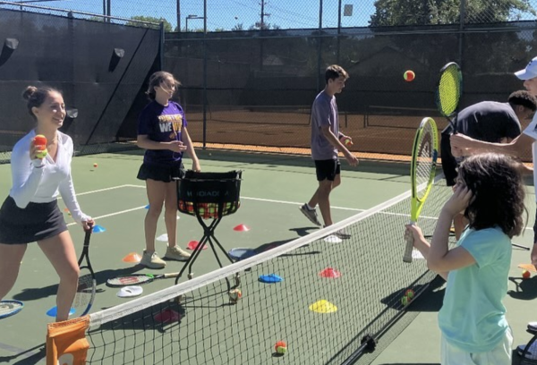 Students with the Sports for Special Needs Club play tennis with students with the ACEing Autism program.
