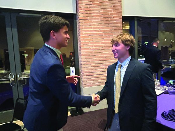 Juniors Max Roeder and Gus Griggs shake hands and congratulate each other over a successful banquet.