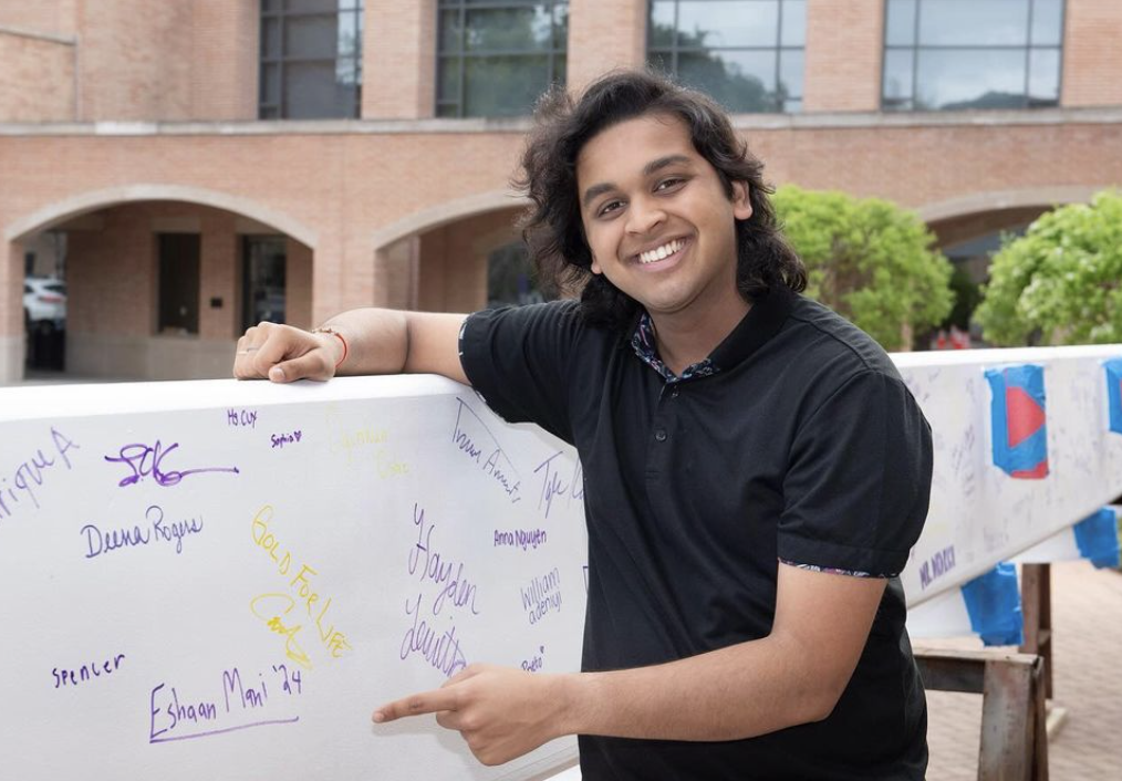 Senior Eshaan Mani points to his signature on the support beam.