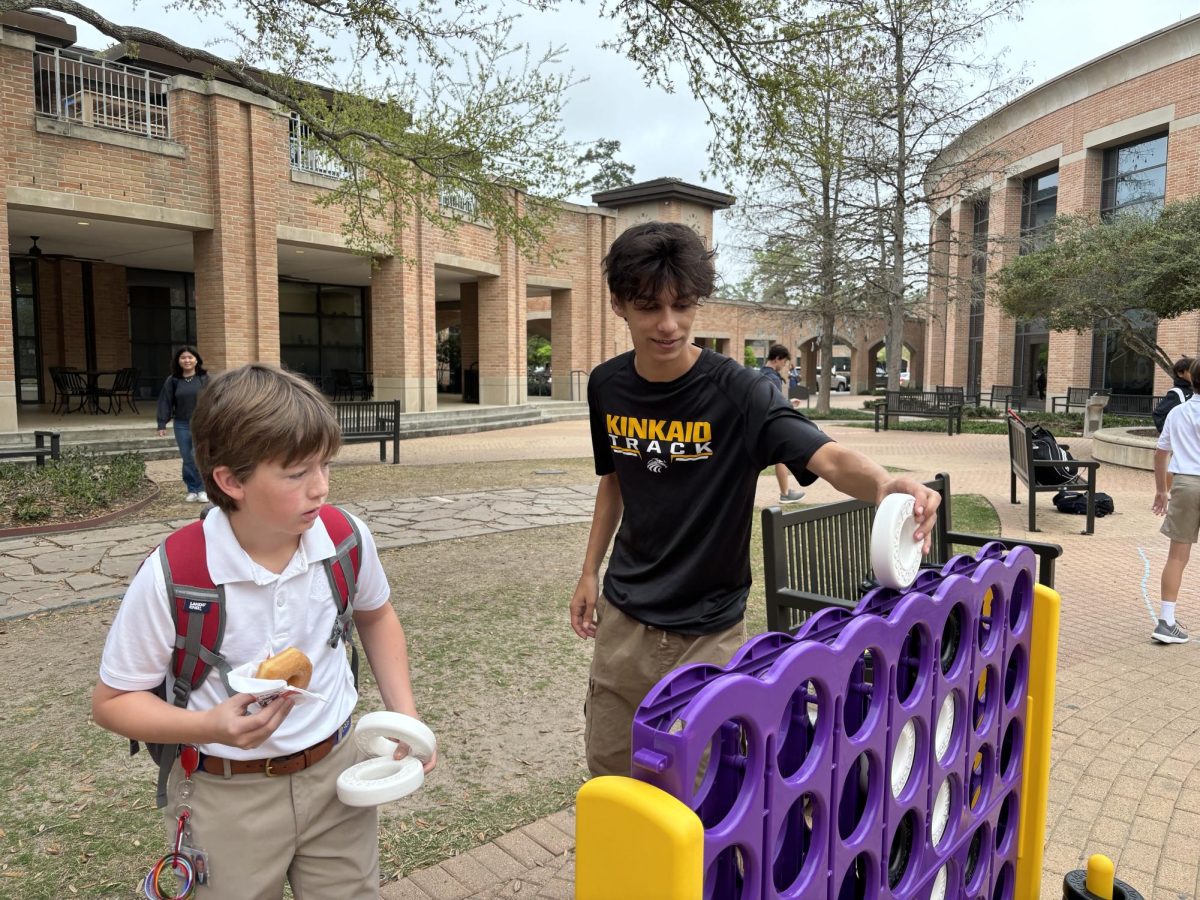 Junior Alexander Miles plays Connect Four with a middle school student.