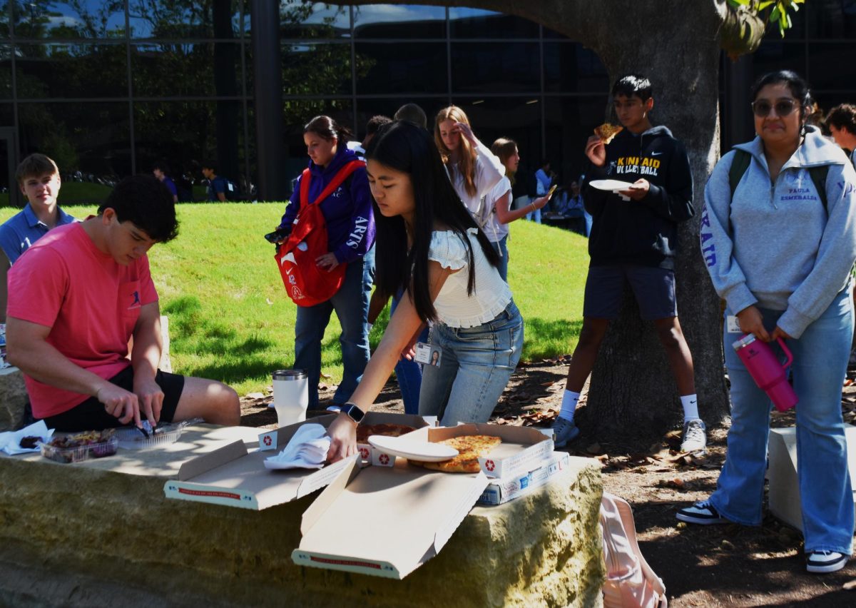 Senior Peer Mentor Maureen Min grabs napkins for her community group as they enjoy eating pizza. “My favorite part of being a Peer Mentor is watching my freshman CG group develop from strangers to friends throughout the past couple of months,” Min said.