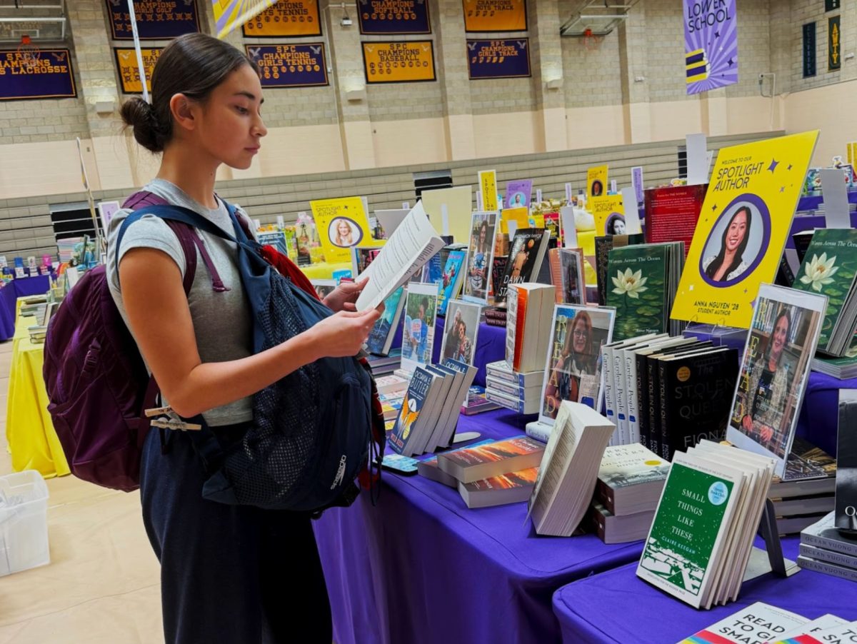 Freshman Olivia Overman is reading sophomore student author Anna Nguyen’s new chapbook, “Woven Across the Ocean”. This book can be purchased during the Book Fair.