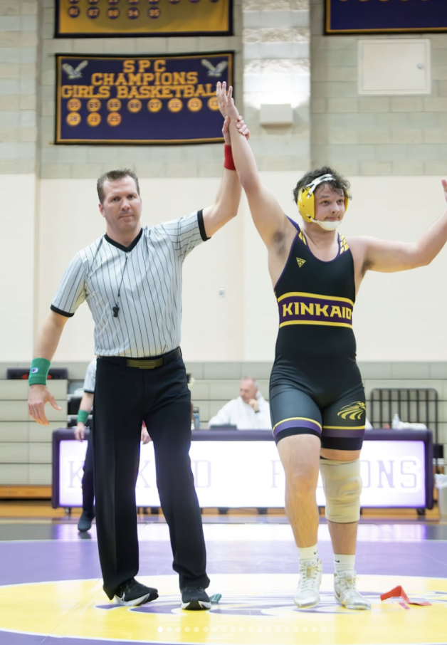 Junior Byson Huber lifts his hand in Melcher Gym after a huge return victory during "War on the Floor." He won his match after undergoing extensive rehabilitation due to an injury. “It is absolutely amazing to see all my hard work pay off in front of my friends and family,” Huber said.