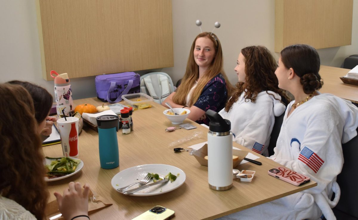 Freshman Kaia Hewitt converses with friends during Spirit of Kinkaid week, or SOK week. Hewitt and her peers were dressed for a space-themed day. Each day of SOK week has a different theme.