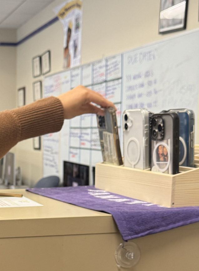 Junior Alexia Hoffman places her phone in the designated case. 