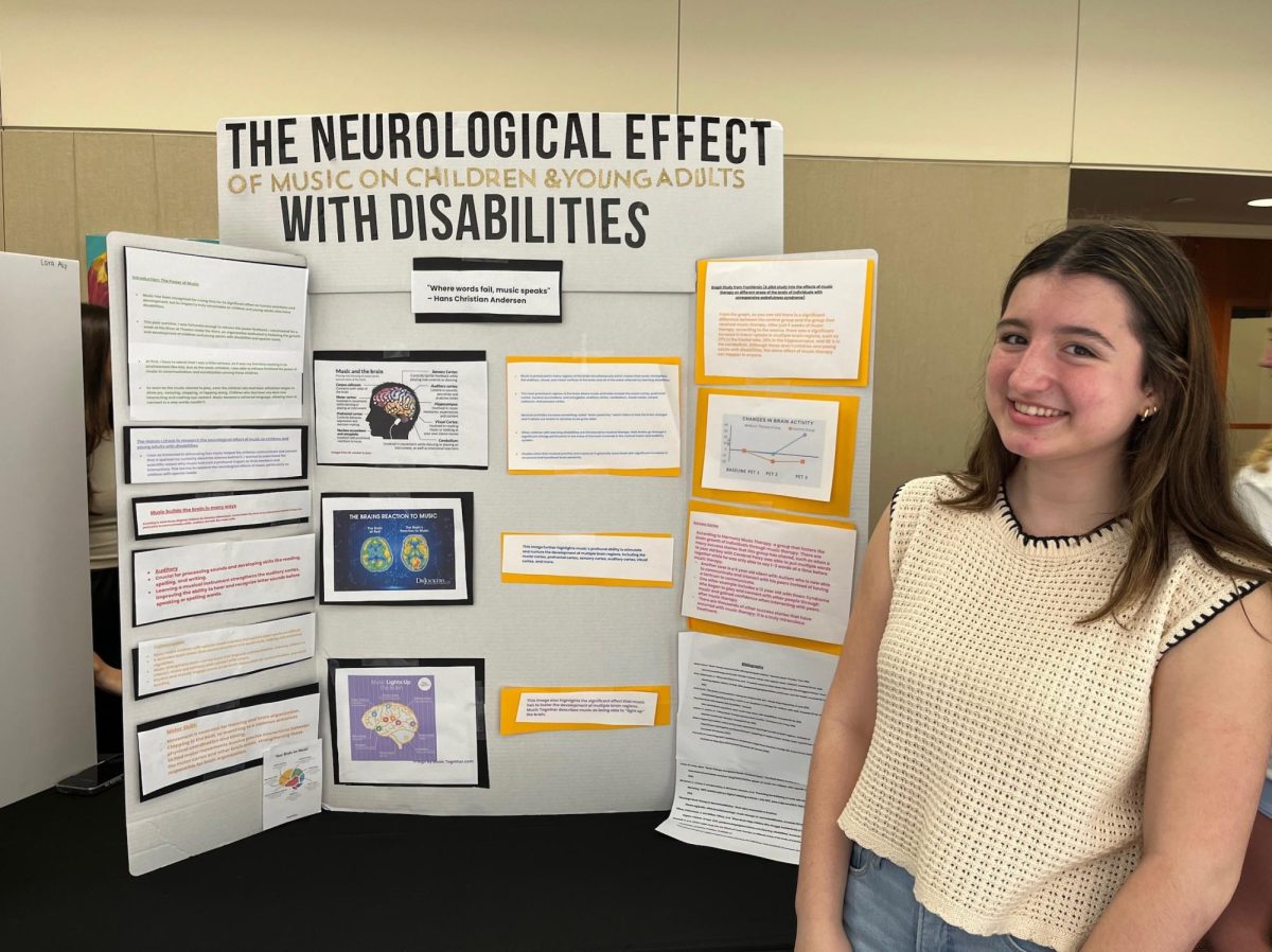 Junior Sienna DeSimone presents her work on the effect of music on children with disabilities at the 2025 STEM Symposium.
