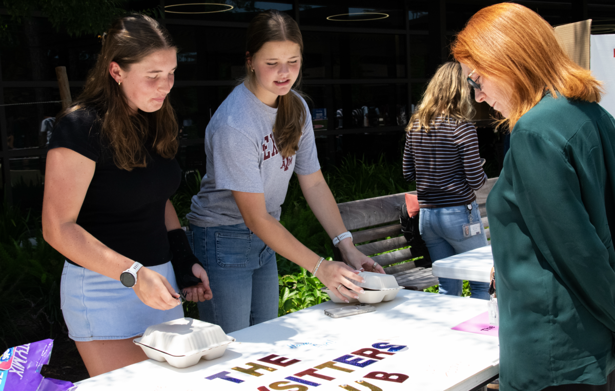 Founders of The Babysitter Club, junior Jilly Leonard and sophomore Lauren Parigi, promote their club to Upper School English teacher Ms. Christa Forster. “I babysit every week, and I want others to learn how to as well,” Leonard said.
