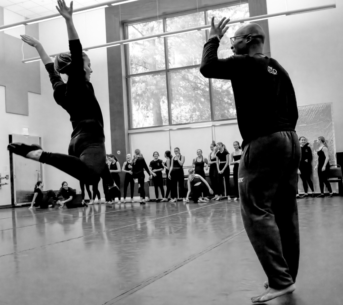A dancer leaps into the air to demonstrate a move for Kinkaid students during a daylong dance workshop at Parish Episcopal School.